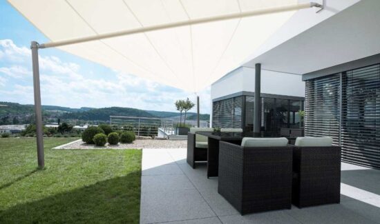 Weißes Sonnensegel über dem Outdoor-Bereich eines Hauses