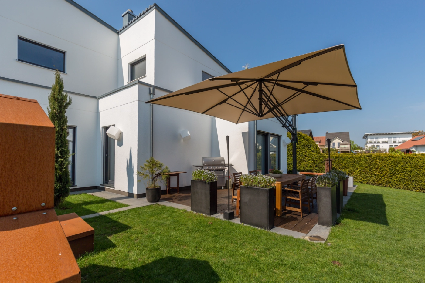 Sonnenschirm über einer Terrasse an einem modernen Haus